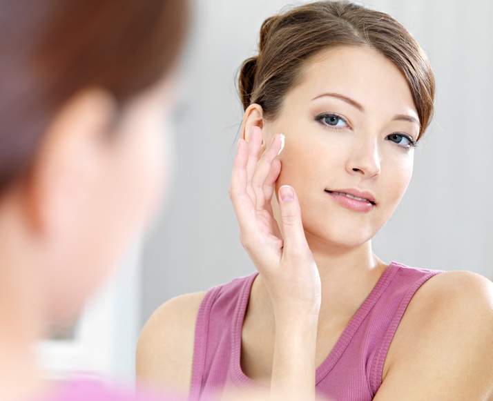 A Holistic Way to Clear Skin, image of a woman looking at mirror