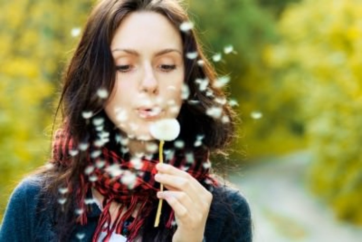 Seasonal Allergies, a Natural Approach, image of a woman blowing a dandy lion.