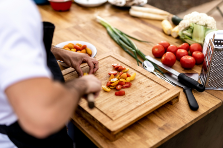 Irritable Bowel Syndrome (IBS), image of a person making food on a cutting board.