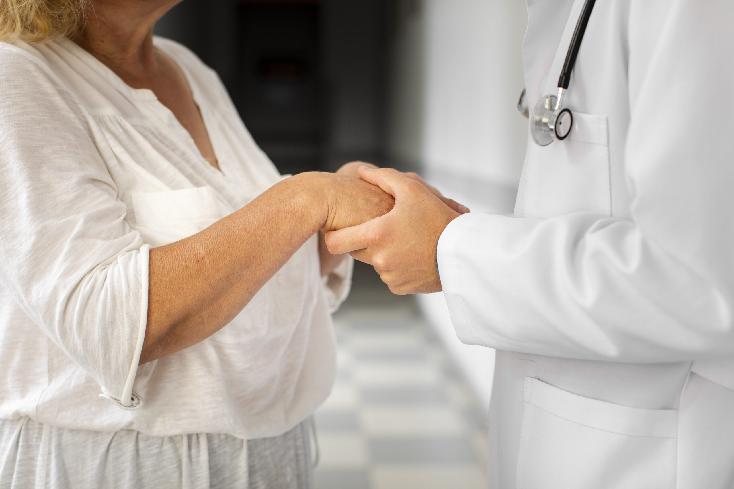 Treating chronic fatigue syndrome, image of a doctor holding a woman patient’s hands.