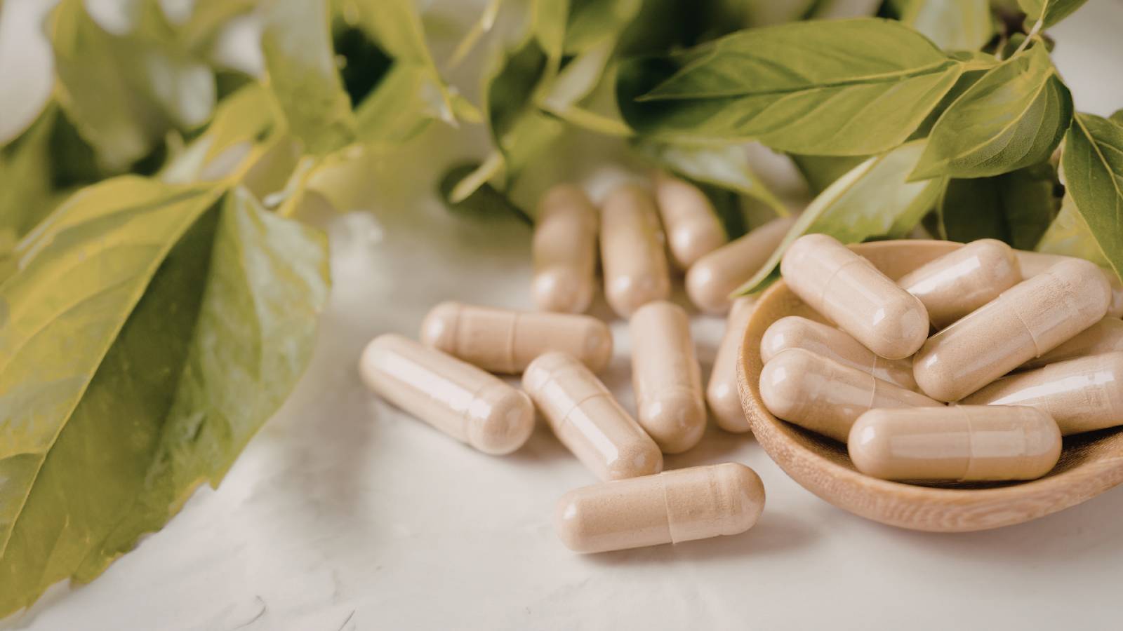 A variety of magnesium supplement capsules alongside magnesium-rich foods including spinach, almonds, and pumpkin seeds on a clean white background