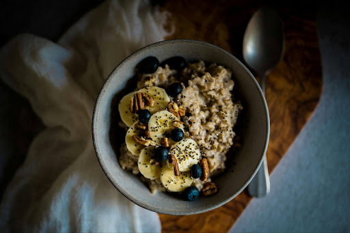 Gastroesophageal Reflux Disease (GERD), image of a bowl of oatmeal with bananas on a wood table.