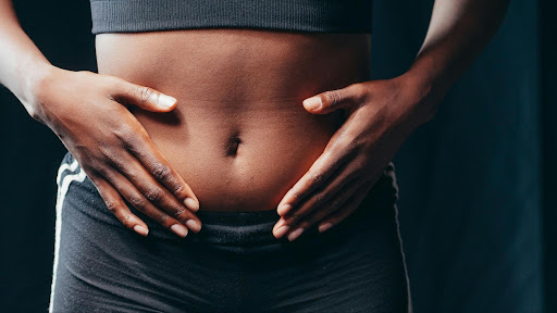 Gastroesophageal Reflux Disease (GERD), image of a woman’s hands touching her bloated stomach.